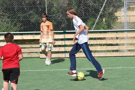 Enfants jouant au foot sur le city stade