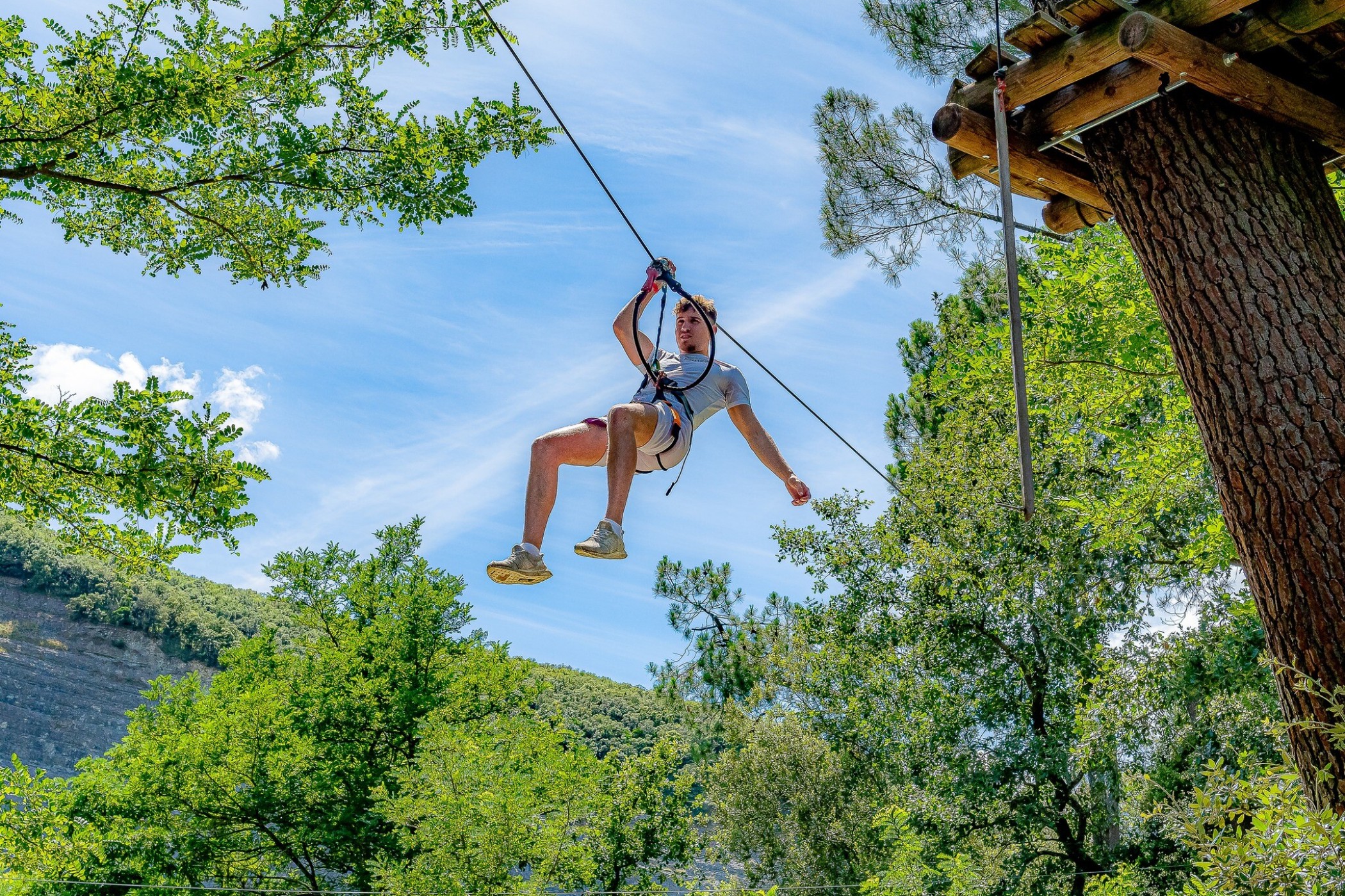 Photo de lactivité scolaire aventure : accrobranche, montrant un jeune sur une tyrolienne